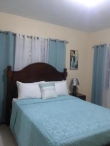Barrianna Villa في خليج مونتيغو: غرفة نوم بسرير ازرق مع بطانية زرقاء