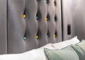 a bedroom with a head board with a bed and a mirror at Point A Kensington Olympia in London +35 photos