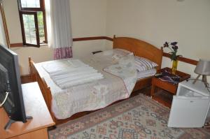 a small bedroom with a bed and a tv at Kont Pension in Antalya