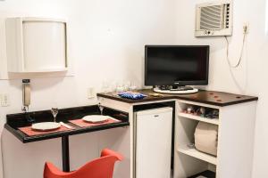 eine kleine Küche mit einem Schreibtisch und einem TV in der Unterkunft MOTEL SHAMPOO (Adult Only) in Brusque