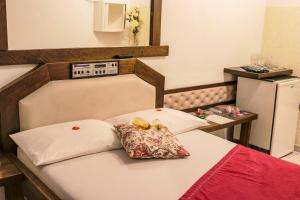 uma cama com duas almofadas num quarto em MOTEL SHAMPOO (Adult Only) em Brusque