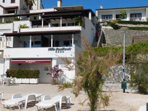 a building with white chairs in front of it at Beach Villa Bozikovic in Podstrana