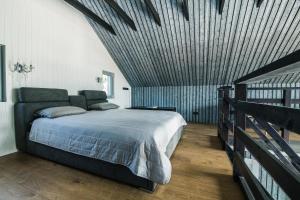 a bedroom with a large bed with a wooden ceiling at Jūras Krasti Harmonija in Jūrmalciems