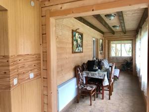 a dining room in a log cabin with a table and chairs at Rukavichka in Pilipets