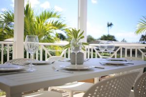 a white table with chairs and wine glasses on a porch at Sea Glass Villa - Spacious 3 Bed / 2 Bath (Lantana 39) in Saint James