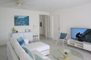 a living room with a white couch and a tv at Sea Glass Villa - Spacious 3 Bed / 2 Bath (Lantana 39) in Saint James