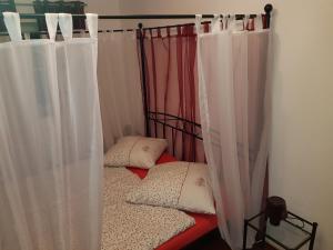 two beds with white curtains in a room at Romantik Ferienwohnung am Tor zum Allgäu in Fuchstal