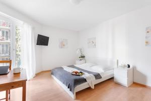 a white bedroom with a bed and a desk at Swiss Star Zurich Sihlfeld - Self Check-In in Zürich