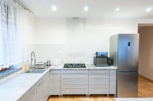 a kitchen with a refrigerator and a sink at Apartament Bardzo Popularny in Bolesławiec