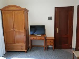 Zimmer mit einem TV und einem Schreibtisch mit einem TV. in der Unterkunft Vivienda Rural Alcazaba in Chipiona