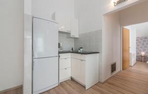 a kitchen with white cabinets and a refrigerator at Maja - Apartment 1 in Funtana