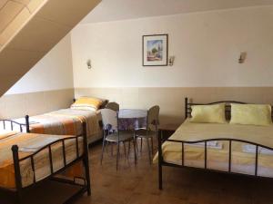 a room with two beds and a table and chairs at Sobe Srebrno Jezero in Veliko Gradište +91 photos
