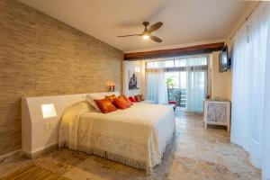 a bedroom with a bed and a ceiling fan at Lotus Beach Hotel - Adults Only in Isla Mujeres