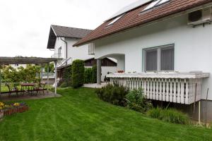 a yard with a white house with a deck at Orchid room in Kranj