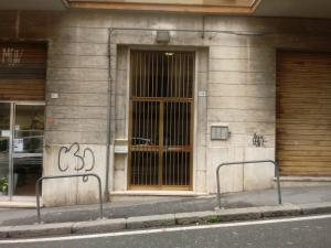 un edificio con una puerta de cristal con graffiti en Travel House en La Spezia