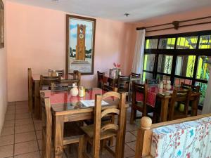 una sala da pranzo con tavolo, sedie e torre dell'orologio. di Posada Sancris a San Cristóbal de Las Casas