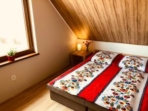 a bedroom with a bed with a quilt on it at Domki Eden z Ballią in Gołubie