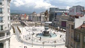 a statue in the middle of a city with buildings at Naumovski Apartments in Skopje