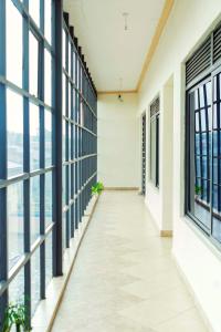 un pasillo vacío en un edificio con ventanas grandes en Japs Motel Mbarara, en Ruhendwa