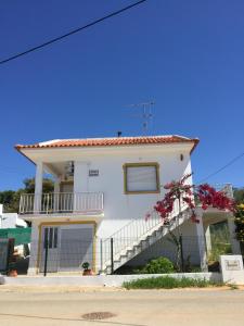 a white house with a balcony and stairs at CASA GRAZINA in Boliqueime