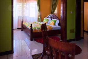 um pequeno quarto com uma cama e 2 cadeiras em Sibyangu Standard Hotel Kampala em Kampala