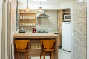 a kitchen with a counter with two chairs at a kitchen island at Apart hotel Copacabana Próximo a praia in Rio de Janeiro