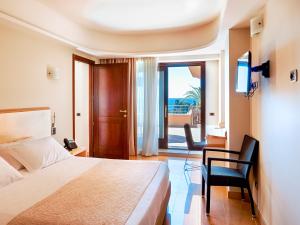 a bedroom with a bed and a desk and a television at Taormina Panoramic Hotel in Taormina