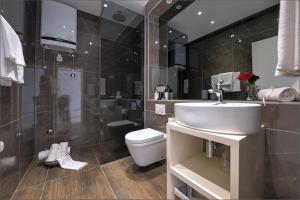 a bathroom with a sink and a toilet and a shower at Via Porto Rooms in Split