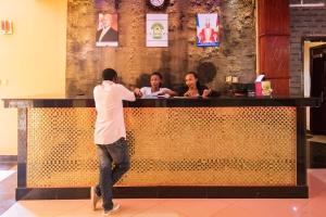 um homem parado em frente a um bar em Sibyangu Standard Hotel Kampala em Kampala