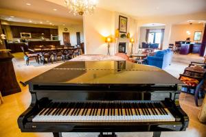 a piano sitting in a living room next to a living room at Aterno Estate & Vineyard, Main House & Guest House in Templeton