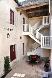 a patio with a table and stairs in a building at Les Sarments in Santenay