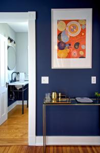 a blue room with a table and a painting on the wall at Nest Hudson in Hudson