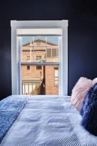 a bedroom with a window view of a building at Nest Hudson in Hudson