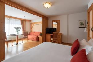 a bedroom with a bed and a living room at Carlo Magno Hotel Spa Resort in Madonna di Campiglio