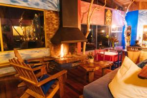 un restaurante con chimenea, sillas y mesa en Mystica, en Naranjos Agrios