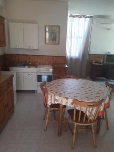 uma cozinha com mesa e cadeiras e uma cozinha com armários brancos em Villa Rustica em Nardò
