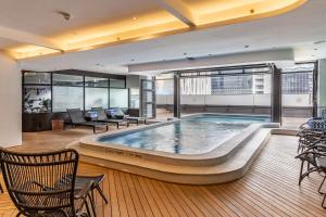 uma grande piscina num edifício com cadeiras e mesas em Luxury Onyx Penthouse with Sea Mountain Views by CTICC Cape Town em Cidade do Cabo