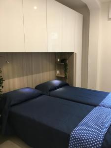 Schlafzimmer mit einem blauen Bett und weißen Schränken in der Unterkunft Beach Jesolo apartment in Lido di Jesolo