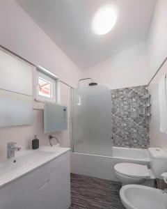 La salle de bains blanche est pourvue de toilettes et d'un lavabo. dans l'établissement Casa do céu, à Silves