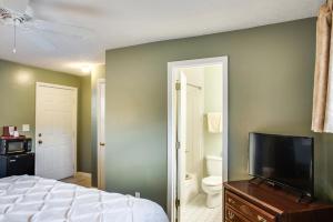 a bedroom with a bed and a flat screen tv at Boxwood Lodge Blowing Rock near Boone-University in Blowing Rock