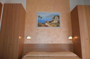 una camera da letto con un dipinto sul muro di Hotel Karin a Rimini