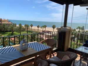 - un balcon avec une table et des chaises et la plage dans l'établissement Mirando al mar. Primera linea de playa, à Isla Canela
