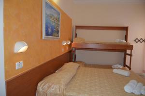 里米尼的住宿－Hotel Karin，一间卧室配有两张双层床和镜子