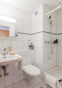 a bathroom with a toilet and a shower and a sink at Swiss Star Tower - Self Check-In in Zürich