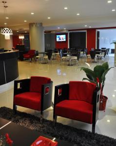 vestíbulo con 2 sillas rojas y zona de comedor en Hotel Las Vegas en Salta