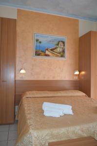 una camera da letto con un letto e due asciugamani di Hotel Karin a Rimini