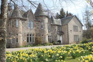 una vecchia casa in pietra con dei fiori davanti di Balvraid Lodge B&B a Inverness