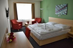 ヴォラリにあるMěstský hotel Bobíkのベッドルーム1室(ベッド1台、椅子2脚、テーブル付)
