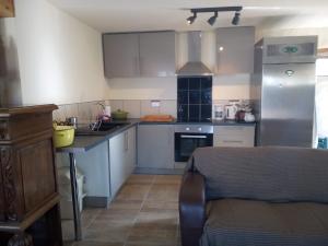 a kitchen with white cabinets and a counter top at Le Petit Savriere B&B in Tronget