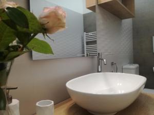 a white bowl sink in a bathroom with a flower at Casa del Corso in Taviano